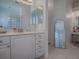 Bathroom vanity with storage, mirrors, and glass block window at 17694 Se 88Th Covington Cir, The Villages, FL 32162