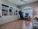 Bright bedroom with built-in shelving, an exercise machine, and wood-look floors at 17694 Se 88Th Covington Cir, The Villages, FL 32162