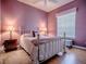 Charming purple bedroom with a gold bed frame, lamps, and a window with blinds at 17694 Se 88Th Covington Cir, The Villages, FL 32162