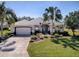 Landscaped front yard with mature landscaping and paved driveway at 17694 Se 88Th Covington Cir, The Villages, FL 32162