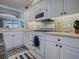 Modern kitchen featuring white cabinets, countertops, stainless steel appliances and tile backsplash at 17694 Se 88Th Covington Cir, The Villages, FL 32162