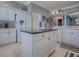 Spacious kitchen with a central island, granite countertops, white cabinetry, and stainless steel appliances at 17694 Se 88Th Covington Cir, The Villages, FL 32162