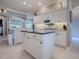 Open kitchen layout with white cabinetry, a central island, modern appliances, and seamless flow to other spaces at 17694 Se 88Th Covington Cir, The Villages, FL 32162