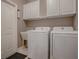 Laundry room includes washer, dryer, cabinets, and a utility sink at 17694 Se 88Th Covington Cir, The Villages, FL 32162