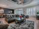Comfortable living room with a dark accent wall, tray ceiling, and a large area rug creating a cozy atmosphere at 17694 Se 88Th Covington Cir, The Villages, FL 32162