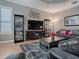 Comfortable living room with hardwood floors, a large television and stylish decor at 17694 Se 88Th Covington Cir, The Villages, FL 32162