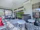 Enclosed patio with table, bar stools, fan, and lounge seating at 17694 Se 88Th Covington Cir, The Villages, FL 32162