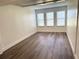 Bright bedroom with three windows, wood-look flooring, and neutral walls at 18203 Sandalwood Dr # 18203, Wildwood, FL 34785