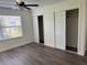 Bedroom with wood-look floors, a ceiling fan, a window, and closet with sliding doors at 18203 Sandalwood Dr # 18203, Wildwood, FL 34785