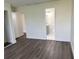 Bedroom with wood-look floors and a view into the bathroom with a gray vanity at 18203 Sandalwood Dr # 18203, Wildwood, FL 34785