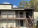 Two story condo with brown accents and stairs leading to the upper units at 18203 Sandalwood Dr # 18203, Wildwood, FL 34785