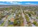 An aerial view shows a cozy neighborhood home near a waterway under a partly cloudy sky at 1840 12Th St, Clermont, FL 34711