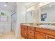 Bathroom with double sinks, granite countertop, updated lighting and walk-in shower at 1840 12Th St, Clermont, FL 34711