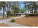 Inviting single-story brick home features mature trees, a green lawn, and a long driveway leading to an attached two-car garage at 1840 12Th St, Clermont, FL 34711