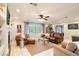Cozy living room featuring leather seating, neutral-toned carpet, a ceiling fan, and plenty of natural light at 1840 12Th St, Clermont, FL 34711