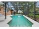 Spacious in-ground pool featuring a screened enclosure, brick accents, and poolside seating at 1840 12Th St, Clermont, FL 34711