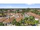 An aerial view of a residential area with well-maintained homes, palm trees, and lush landscaping under a clear, blue sky at 1923 Greeleyville Ter, The Villages, FL 32162