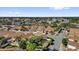 An aerial view of homes in a well-kept neighborhood with mature landscaping, palm trees, and consistent architectural styles at 1923 Greeleyville Ter, The Villages, FL 32162