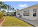 Green backyard with lush lawn, mature landscaping, and a view of the house at 1923 Greeleyville Ter, The Villages, FL 32162