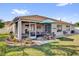 Backyard with patio, green lawn, and landscaping offering a relaxing outdoor space at 1923 Greeleyville Ter, The Villages, FL 32162
