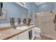 Bathroom with a glass door shower and blue walls, providing a refreshing atmosphere at 1923 Greeleyville Ter, The Villages, FL 32162
