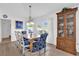 Charming dining room with natural light, hardwood floors, stylish blue chairs, and a china cabinet at 1923 Greeleyville Ter, The Villages, FL 32162