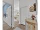Hallway leads to a light-filled bedroom with neutral tones and wood-look floors at 1923 Greeleyville Ter, The Villages, FL 32162