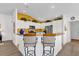 Bright kitchen with white cabinetry, breakfast bar, stainless steel appliances, and yellow accent wall at 1923 Greeleyville Ter, The Villages, FL 32162