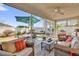 Screened patio featuring comfortable seating, ceiling fan, and a view of the green backyard at 1923 Greeleyville Ter, The Villages, FL 32162