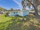 Charming backyard with green grass, mature trees, and a well-maintained home exterior at 2 Heather Ln, Fruitland Park, FL 34731