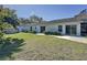 Backyard featuring well-maintained lawn, mature trees, and a covered lanai that enhance the outdoor space at 2065 Braxton St, Clermont, FL 34711