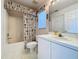 Well-lit bathroom featuring a shower-tub combo, a large mirror, and a vanity with a white countertop at 2065 Braxton St, Clermont, FL 34711