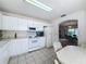 Well-lit kitchen offering white appliances, tile flooring, and a view of the nearby breakfast area at 2065 Braxton St, Clermont, FL 34711