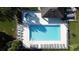 Overhead shot of a sparkling pool and hot tub with lounge chairs in a fenced in area at 2065 Braxton St, Clermont, FL 34711