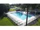 Aerial view of a community pool with lounge chairs, hot tub, and lush landscaping at 2065 Braxton St, Clermont, FL 34711
