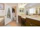 This primary bathroom features double sinks with warm cabinets and flooring, and includes a separate toilet room at 22027 Belgian Ct, Mount Dora, FL 32757