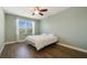 Serene bedroom with a large window, tiled floors, neutral walls, and a ceiling fan, creating a tranquil retreat at 22027 Belgian Ct, Mount Dora, FL 32757
