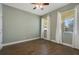 This bedroom features wood floors and two windows with decorative, flowing curtains at 22027 Belgian Ct, Mount Dora, FL 32757