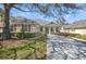 Inviting one-story home with a well-manicured lawn, mature trees, and a cozy front porch, enhancing curb appeal at 22027 Belgian Ct, Mount Dora, FL 32757