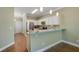 Bright kitchen featuring white cabinets, granite countertops, a breakfast bar, and stainless steel appliances at 22027 Belgian Ct, Mount Dora, FL 32757