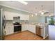 Modern kitchen with stainless steel appliances, granite countertops, and ample cabinet space for storage and meal prep at 22027 Belgian Ct, Mount Dora, FL 32757