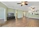 Open-concept living space showcasing wood-look tile floors, a media center, and seamless flow to the kitchen at 22027 Belgian Ct, Mount Dora, FL 32757