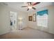 Bright and airy bedroom featuring neutral carpet, a ceiling fan, and a window with natural light at 2471 Holly Berry Cir, Clermont, FL 34711