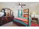 Well-lit bedroom features a four-poster bed, a dresser with a mirror, and closet storage at 2471 Holly Berry Cir, Clermont, FL 34711