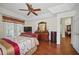 Bedroom featuring a decorative ceiling fan, wood floors, and a large dresser at 2471 Holly Berry Cir, Clermont, FL 34711