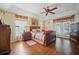 Bright main bedroom featuring wood floors, a tray ceiling, and access to the exterior at 2471 Holly Berry Cir, Clermont, FL 34711