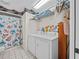 Laundry area featuring a washer, a dryer and a floral shower curtain at 25013 Adair Ave, Sorrento, FL 32776