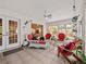 Bright sunroom featuring tile floors, white wicker furniture, ceiling fan, and natural light through large windows at 25013 Adair Ave, Sorrento, FL 32776