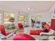 Bright sunroom featuring tile floors, white wicker furniture, ceiling fan, and natural light through large windows at 25013 Adair Ave, Sorrento, FL 32776