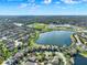 Aerial view showcases homes and a scenic lake with a school campus in the background at 2505 Civitas Pl, Casselberry, FL 32707
